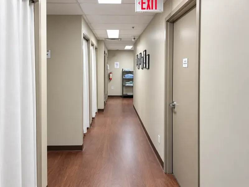 The curtained change rooms at 960 Lawrence Avenue West, with folded gowns on a shelf at the end of the hall